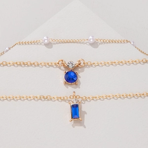 Vue détaillée du collier triple épaisseur en or avec émeraudes et perles