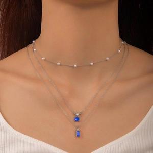 Gros plan d'un collier triple rangée argenté avec pierres bleues et petites perles