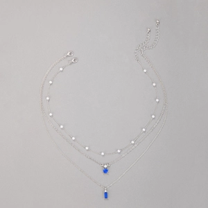 Vue détaillée du collier argenté multicouche avec pierres bleues et perles blanches