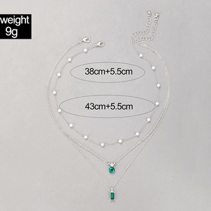 Détail du collier argenté multicouche avec perles et pendentifs de pierre verte