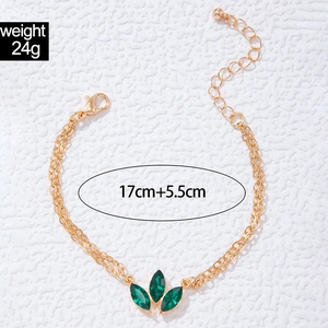 Detail of gold-plated double-chain bracelet with three green marquise stones