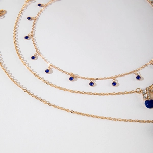 Détail du collier multi-rangs doré avec pendentif cerise en saphir bleu et cristaux