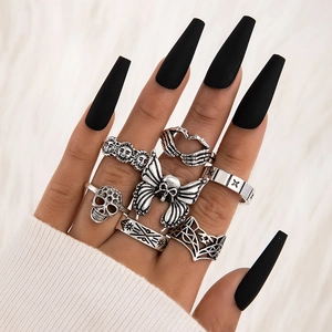 Close-up of gothic punk ring set featuring skulls and butterflies on a hand