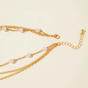 Détail du fermoir mousqueton doré et chaîne d'extension de collier à perles superposé