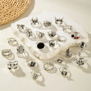 Close-up of gothic punk ring set with skull, spider, and butterfly designs in aged silver