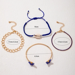 Détail d'un ensemble de quatre bracelets dorés avec papillons bleus et strass