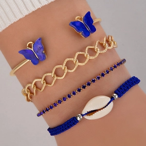 Gros plan d'un ensemble de bracelets papillon bleus avec chaînes dorées et coquillage