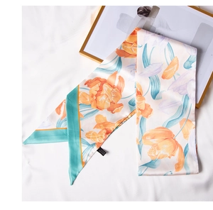Detalle de pañuelo de seda con estampado de tulipanes y bordes verde menta en fondo texturizado