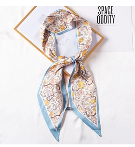Detail of floral silk twilly scarf with blue trim on a stylish aesthetic background