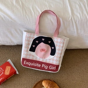 Close-up of insulated canvas lunch bag with cartoon pig and pink checkered pattern