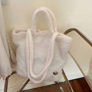 Detail of soft white plush tote bag showing fluffy texture and metal hardware