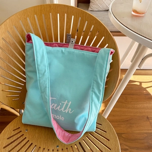 Blue and pink quilted tote bag with Faith mole print on a rustic wooden chair