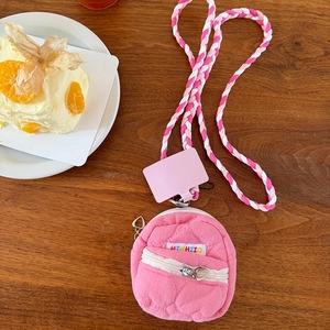 Dettaglio mini borsa trapuntata rosa con cordino intrecciato su tavolo in legno