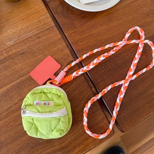 Dettaglio della mini borsa per cuffie trapuntata verde con tracolla intrecciata colorata
