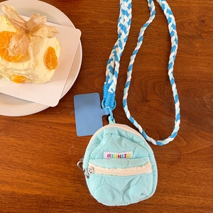 Dettaglio della mini borsa trapuntata verde menta per auricolari con cordino blu