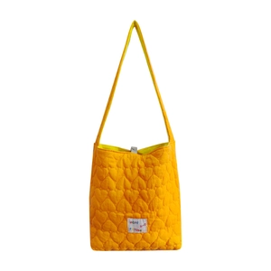 Orange heart-quilted tote bag with adjustable strap and Hope label on white background
