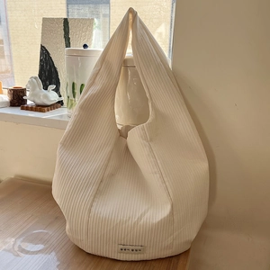 Detailed view of cream vertical pleated fabric texture on a large casual tote bag