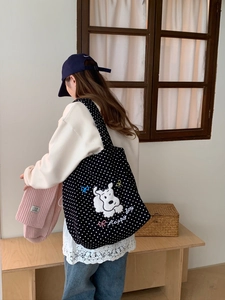Detail of black polka dot tote bag with cartoon puppy embroidery and Happy day text
