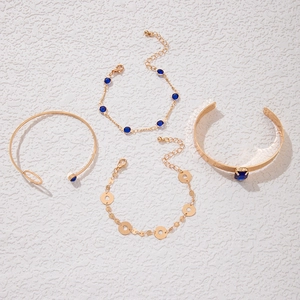 Détail d'un ensemble de 4 bracelets dorés orné de pierres bleues et de papillons
