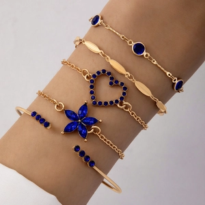 Vue détaillée du set de cinq bracelets dorés avec pierres bleu foncé et charms en cœur