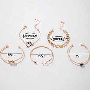 Détail macro d'un ensemble de 5 bracelets dorés avec cristaux bleus et breloques soleil