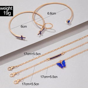 Détail du lot de quatre bracelets dorés avec papillon en cristal bleu et breloque