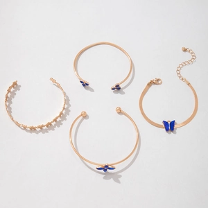 Détail d'un ensemble de quatre bijoux dorés ornés de papillons et de fleurs bleues