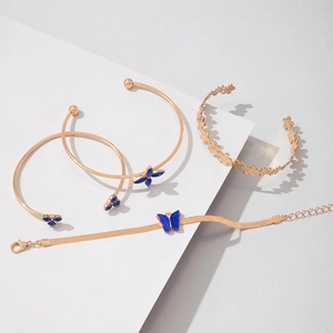 Gros plan sur l'ensemble de quatre bracelets dorés avec papillons bleus et détails