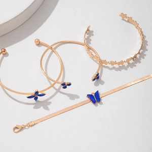 Détail de bracelets dorés avec motifs de papillons bleus et fleurs en émail élégants