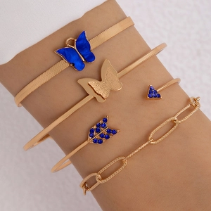 Détail d'un ensemble de quatre bracelets dorés avec papillons bleus et strass brillants
