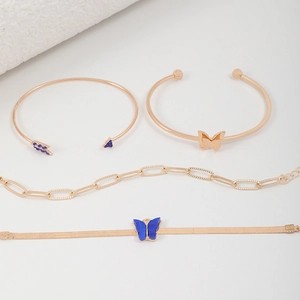 Détail d'un ensemble de quatre bracelets dorés avec breloques papillons bleus et strass