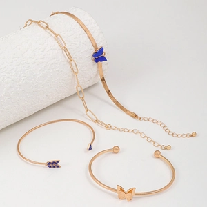 Détail d'un ensemble de quatre bracelets dorés avec papillons bleus et cristaux