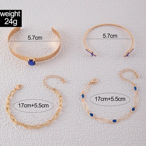 Détails du coffret de quatre bracelets dorés avec saphirs bleus et breloques papillon