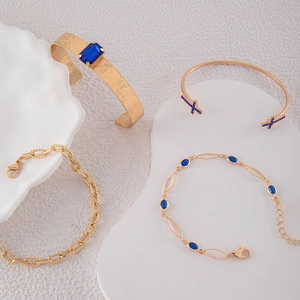 Détail d'un ensemble de quatre bracelets dorés avec pierres bleues et finition martelée