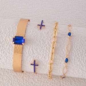 Détail d'un lot de quatre bracelets dorés sertis de strass bleus et textures martelées