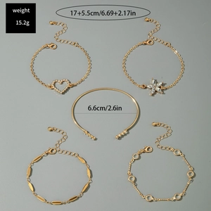 Détail d'un ensemble de cinq bracelets dorés avec breloques papillon bleu et cœur en diamant
