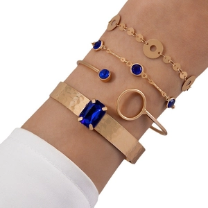 Élégant ensemble de 4 bracelets dorés avec pierres bleues et joncs en métal texturé