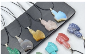 Macro detail of assorted natural stone axe pendants with smooth polished finish and cords