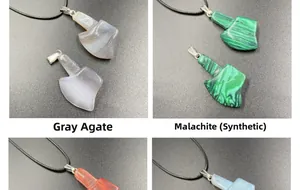 Detail view showing assorted stone axe pendants in grey agate and synthetic malachite