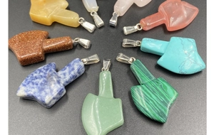 Detailed collection of axe-shaped natural gemstone pendants in various colors and textures