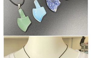 Detailed view of axe-shaped natural stone pendants in quartz and agate with woven cords