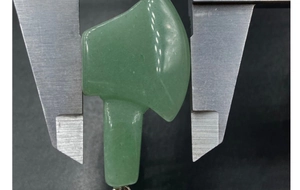 Measuring width of carved green gemstone axe pendant with a digital caliper tool