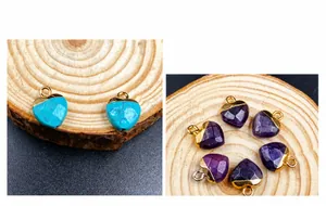 Detailed view of faceted heart pendants in turquoise and amethyst with gold-plated edges