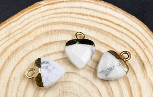 Macro view of heart-shaped marble and gold pendant on a textured wooden surface