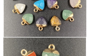 Macro detail of multi-color heart-shaped crystal stone pendants with gold metal edges