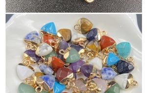 Macro shot of assorted heart-shaped semi-precious gemstone pendants with gold-plated metal loops