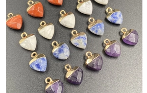 Close-up of heart-shaped natural stone pendants with faceted cut and gold-plated bail