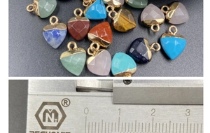 Macro view of heart crystal pendants with gold edges showing size on a caliper