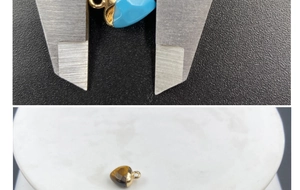 Macro shot of a faceted heart-shaped semi-precious stone pendant being measured by calipers