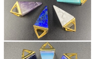 Detailed close-up of geometric pyramid gemstone pendants with golden metal clasps